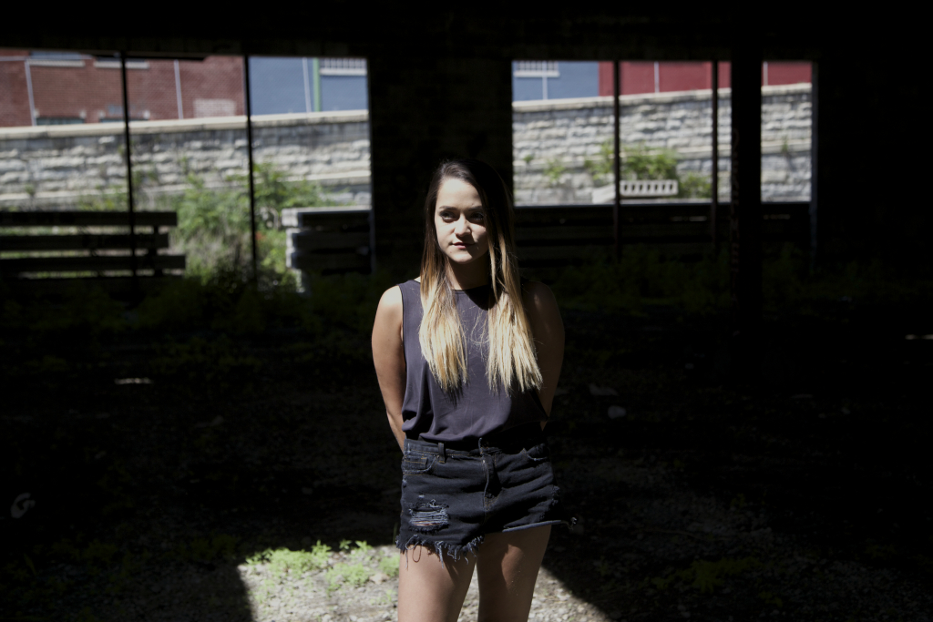 woman with long hair standing in the shadows